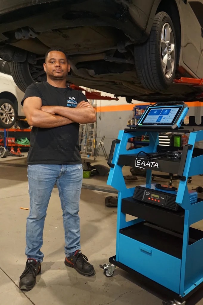 Mecânico da SJ Auto Reparadora junto a um veículo elevado na oficina